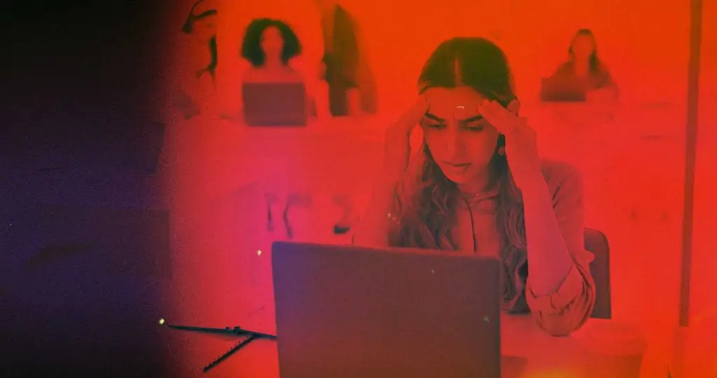 Woman at her laptop with her head in her hands, looking frustrated